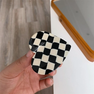 Detail of a heart-shaped claw clip with classic black and white checkered acetate patterns