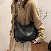 Vista de estilo de vida de un bolso bandolera negro en cuero granulado con bolsillos