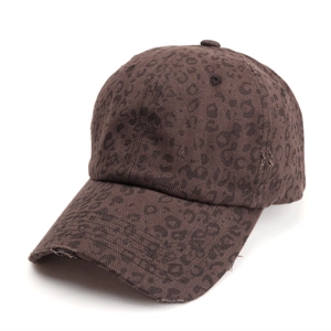 Close-up of distressed leopard print baseball cap with vintage frayed edges and cotton texture