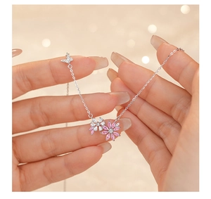Detailed macro of flower and butterfly pendant necklace with pink and white cubic zirconia