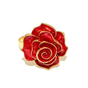 Detailed close-up of a red enamel rose napkin ring with golden metallic edges and plating