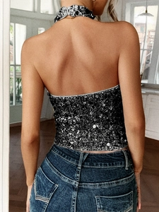 Detailaufnahme des schwarzen Pailletten-Halterneck-Tops und des passenden Halsschmucks