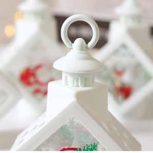 Detail of white Christmas lantern top handle and festive illustrations with warm bokeh light