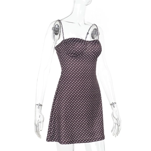 Dettaglio del mini abito nero a pois con design a corsetto e spalline sottili doppie