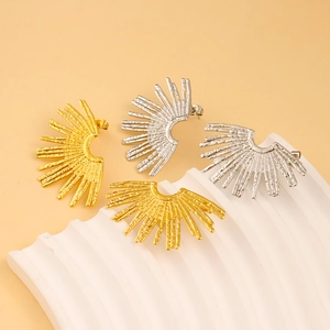 Close-up of vintage fan-shaped earrings in gold and silver with hammered metal texture