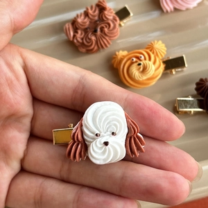 Close-up of handmade puppy cookie hair clip with detailed white and brown resin fur texture