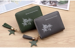 Close-up of green and gray mini coin purses with bamboo prints and star tassels
