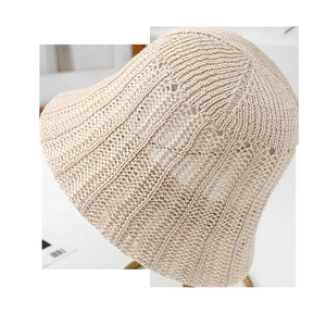 Detailed macro view of beige knit bucket hat showing crochet texture and breathable stripes