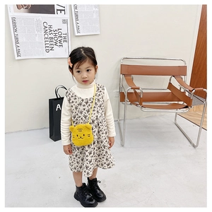 Detail of yellow plush tiger crossbody bag paired with floral girl's dress set