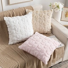 Three plush pillow covers with 3D tulip floral patterns on a beige sofa