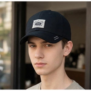 Close-up of black cotton baseball cap with vintage patch and white wave embroidery