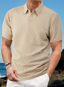 Gros plan d'un polo beige pour homme montrant la texture détaillée en chevrons sur la plage