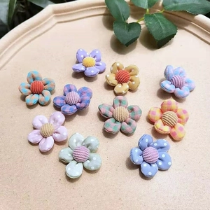 Detailed close-up of 10 colorful fabric flowers in polka dots and plaid for DIY hair accessories