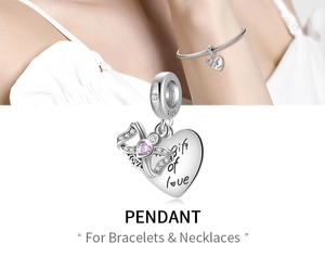 Macro detail of 925 sterling silver heart charm with pink gems and love engraving