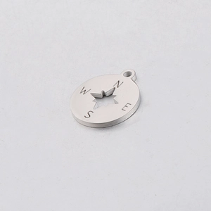 Detail of mirror-polished stainless steel compass pendant with star cutout and N E S W engraving
