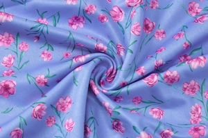 Close-up of soft purple floral fabric with pink blossoms and fine textile texture