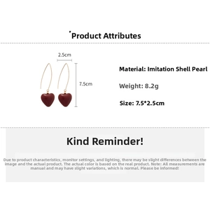 Detail view of red heart pearl drop earrings with 7.5cm length and gold hook specs