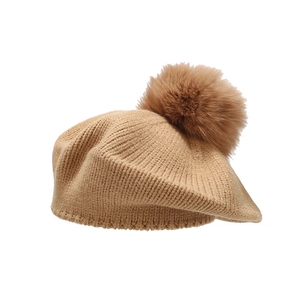 Classic camel knit beret hat with a fluffy faux fur pom-pom shown in a centered front view