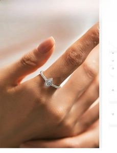 Macro shot of marquise-cut zircon ring with micro-paved silver setting on a hand
