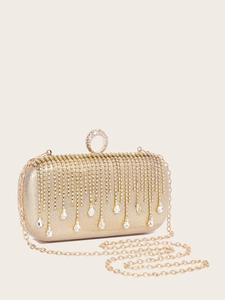 Detail of elegant gold evening clutch bag with sparkling rhinestone tassels and chain