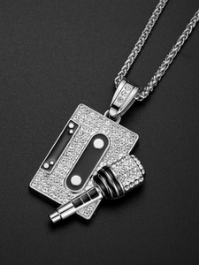 Detailed macro of hip hop cassette and microphone pendant with shiny crystals and wheat chain