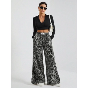 Detail of grey leopard print high-waisted wide-leg trousers with a black crop top set