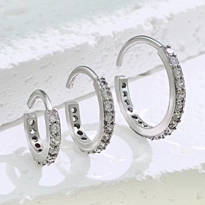 Drei Größen silberne Creolen aus Sterlingsilber mit weißen Zirkonia auf weißem Stein
