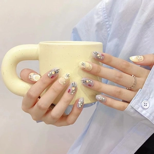 Handmade press-on nails with purple and yellow floral patterns and 3D pearl accents
