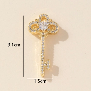 Detail showing the 3.1cm x 1.5cm golden key pendant with crystals on beige background