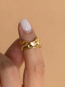 Detail showing irregular gold lava texture and wavy pattern of the stainless steel ring