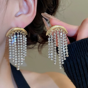 Détail de boucles d'oreilles lune dorées de luxe avec glands en cristal scintillant