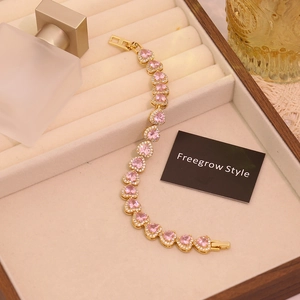 Detail of gold heart bracelet with pink zircon stone and sparkling micro-pave crystals