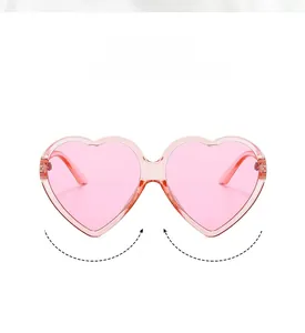 Close-up of pink heart-shaped sunglasses with translucent frames and metal hinges