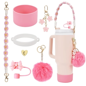 Detailed pink accessory set including straw cover, lanyard, and charms for Stanley tumbler