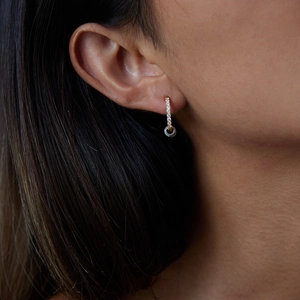 Close-up of modern two-tone 18K gold plated stainless steel hoop earrings with diamonds