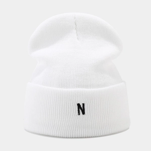 Close-up of white knitted beanie featuring black N letter embroidery and thick texture