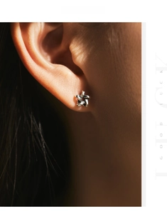 Close-up of vintage silver S925 hollow star stud earring worn on model's ear
