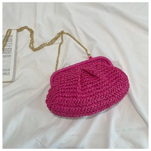Detail of rose red woven cloud bag featuring straw texture and fine gold chain strap