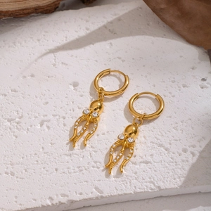 Goldene Oktopus Ohrringe mit Zirkonia-Steinen auf weißem, strukturiertem Hintergrund
