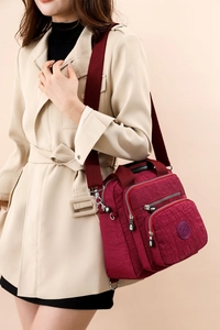 Détail du sac à langer en nylon bordeaux imperméable avec poches multiples et large bandoulière