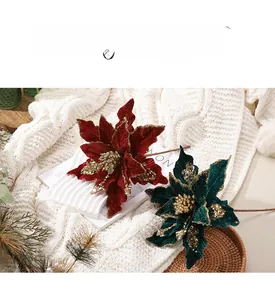 Détail de fleurs de poinsettia en velours rouge et vert avec des paillettes dorées