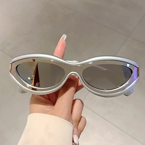Detail of silver futuristic metallic cat-eye sunglasses with oval dark lenses for Y2K style
