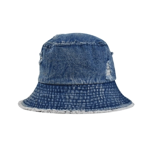 Detailed view of the frayed edge and distressed texture on blue denim bucket hat