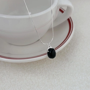 Minimalist 925 silver snake chain necklace featuring an oval black agate pendant on a white cup