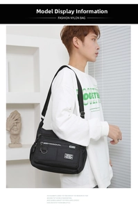 Man wearing large black crossbody bag showing multi-pocket design and adjustable strap