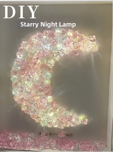 Close-up of DIY moon-shaped night light with pink crystals and I Love You golden lettering