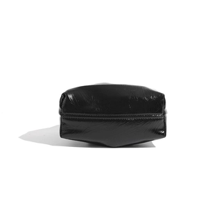 Detailed close-up showing the glossy black leather bottom and high-quality stitching of the bag