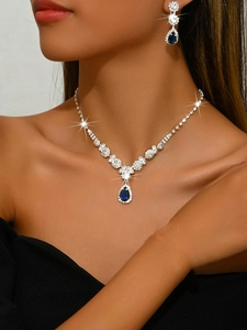 Close-up of bridal jewelry set with sparkling blue teardrop crystals and zircons