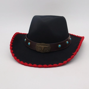 Dettaglio cappello western con perle turchesi, emblema a toro e bordo rosso all'uncinetto