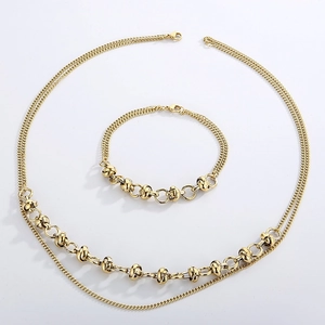 Close-up of golden double-layer necklace and bracelet featuring unique knot links